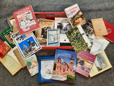 de nombreux livres qui sont rangés dans une boîte rouge