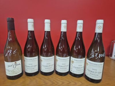 six bouteilles de vin sont alignées sur une table en bois