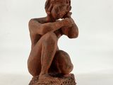 a statue of a woman sitting on top of a rock