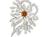 une broche en forme de losange, orange et blanche, signée Van Cleef