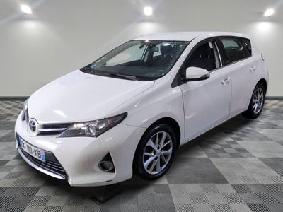 La Toyota Corolla blanche est garée dans une pièce dont le sol est en damier.