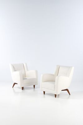 two white chairs sitting next to each other on a white floor