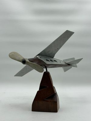 une petite maquette d'avion de chasse posée sur un socle en bois
