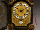 a gold clock with black and white roman numerals on it