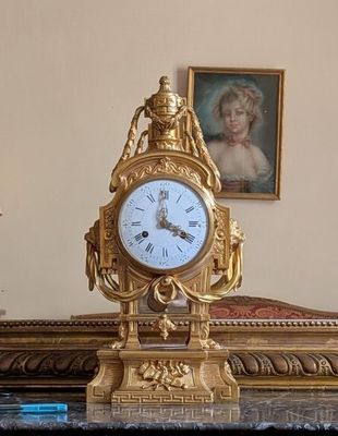 une horloge en or posée sur une table en marbre