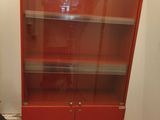 an image of a red bookcase with glass doors