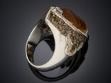 an image of a silver ring with a brown stone in it