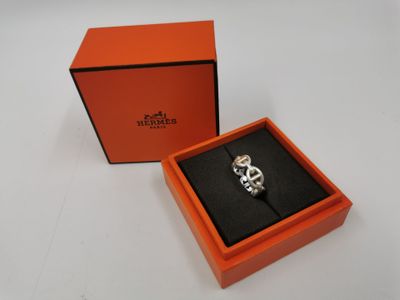 une boîte orange contenant un anneau argenté, posée sur une surface blanche