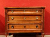 une commode en bois devant un mur rouge