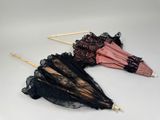 deux parapluies ornés de dentelle, posés sur une table