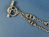 a close up of a silver chain with a clasp on a blue background