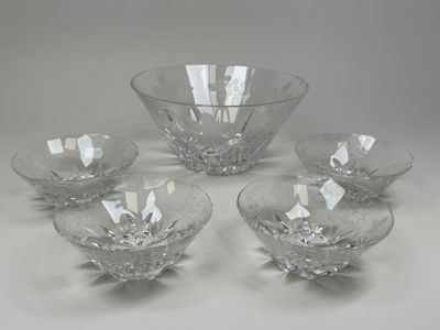 quatre bols en verre transparent et un bol posé sur une surface blanche