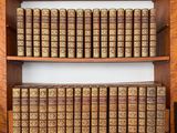 une vieille bibliothèque remplie de nombreux livres posés sur des étagères en bois