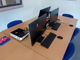 trois ordinateurs posés sur le bureau dans la pièce