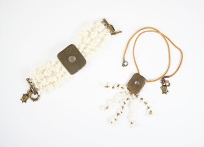 Deux bijoux sont posés sur une surface blanche.