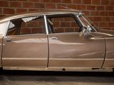 a brown car parked in front of a brick wall