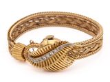 gros plan d'un bracelet en or et diamants sur fond blanc