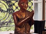 une statue représentant une personne assise sur une table