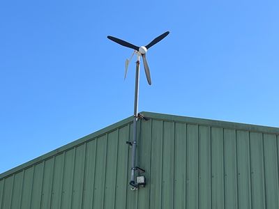 une éolienne au sommet d'un immeuble, avec un ciel bleu en arrière-plan
