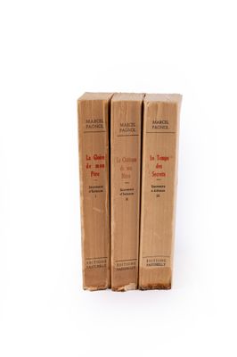 trois livres superposés sur une surface blanche