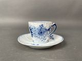 a blue and white cup and saucer sitting on a table