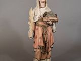 statue d'une femme tenant un panier et un oiseau dans ses mains