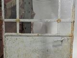 une vieille porte métallique dotée d'un hublot en verre