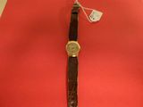 wrist watch on a red surface with a price tag attached to it