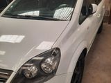 La voiture blanche est garée dans le garage, à côté d'autres voitures.