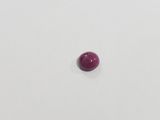a single red stone on a white surface