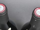two bottles of wine are sitting on a table next to each other