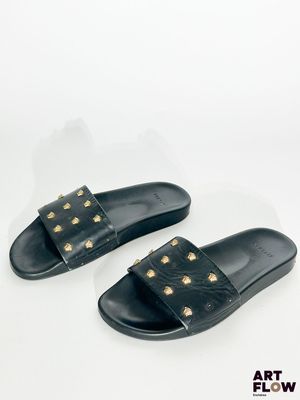 une paire de sandales noires ornées de clous dorés