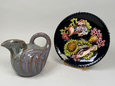 two vases and a plate sitting next to each other on a table