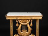a gold and marble table with harps on it