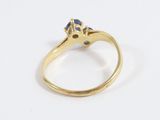 a close up of a gold ring with a blue sapphire stone