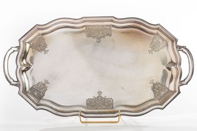 an ornate silver tray with handles and handles on a stand