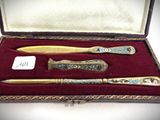 a box with a pen, knife, and other items in it