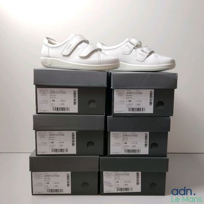 a stack of boxes with a pair of white shoes on top of them