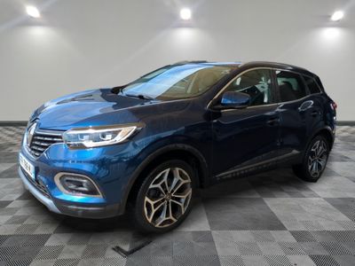 un 4x4 bleu garé sur un sol en damier dans un garage