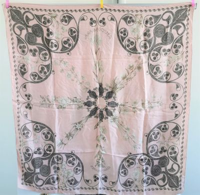 une écharpe rose et noire suspendue à une corde à linge