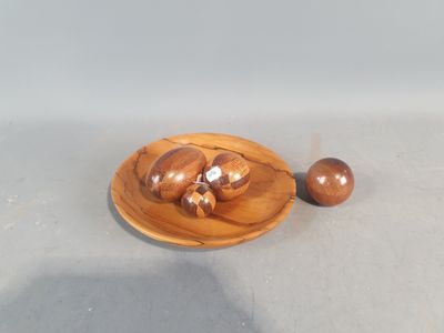 une petite assiette en bois sur laquelle sont posés deux écrous