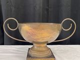 une image représentant un trophée en or posé sur une table blanche