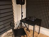 a desk with a keyboard and speakers in the corner of a room