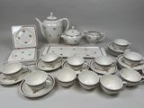 a lot of white dishes and cups on the table