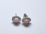 une paire de boucles d'oreilles en perles roses et diamants sur fond blanc