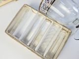 une boîte de cigarettes et un verre posés sur une table