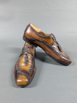 pair of men ' s brown leather shoes on a gray surface