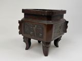 une boîte en bois ornée de sculptures, posée sur un socle