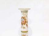 a white vase with a floral design on it