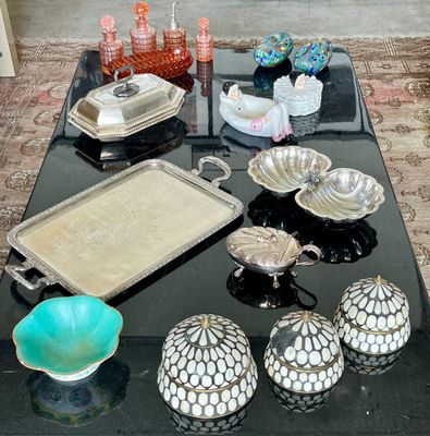 une table noire sur laquelle est posé un plateau contenant des objets en argent et en verre
